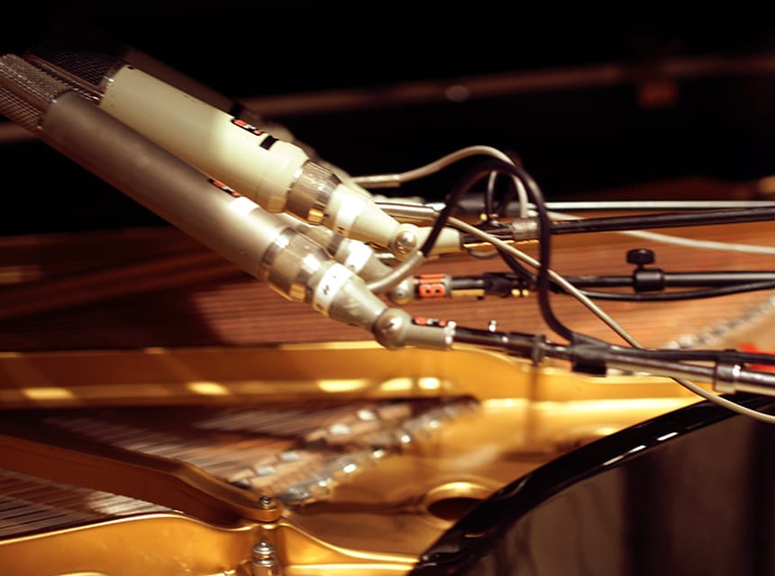 Steinway Model Bの弦の上に並ぶヴィンテージマイク（Universal Audio公式）