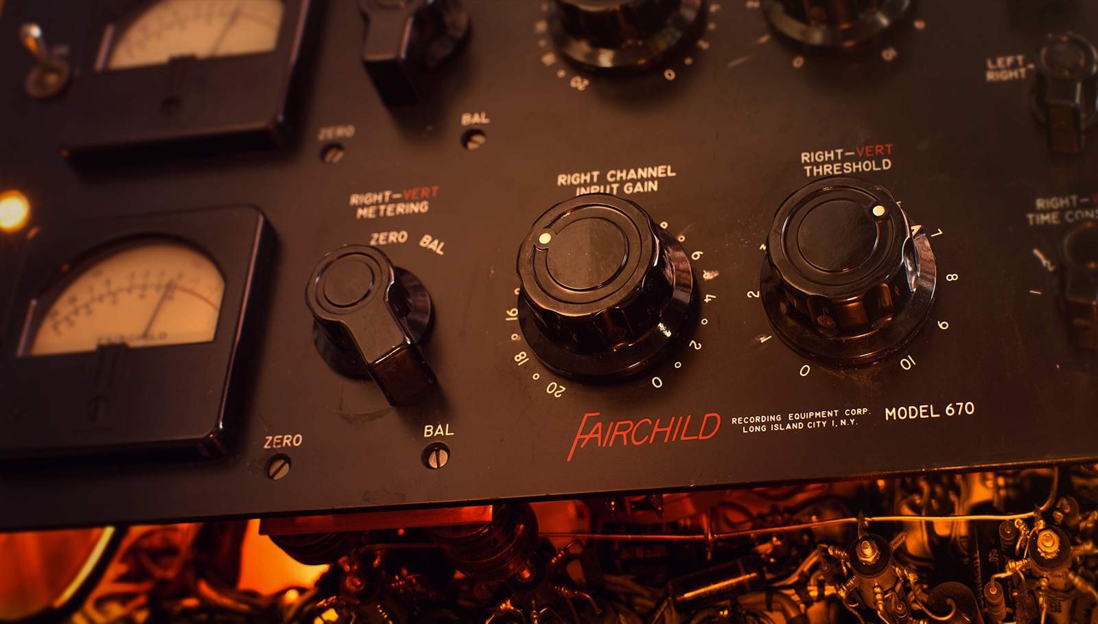 Fairchild 670 のつまみと VU メーターを斜めから写した画像。黒いパネルに大きなつまみが並ぶ(Universal Audio 公式の画像)